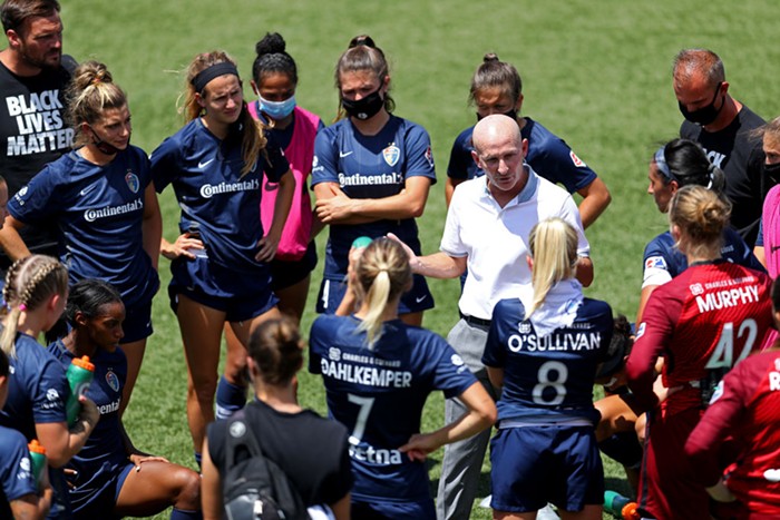 A photo of former Thorns couch Paul Riley speaking with members of the North Carolina Courage.