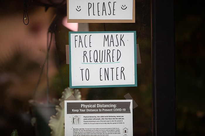 A sign requiring face masks before entering