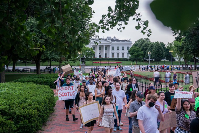 A group of pro-choice protesters walking in front of the White House